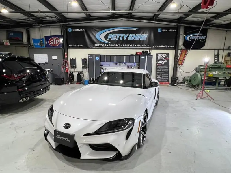 White Toyota Supra under the Petty Shine banner after paint correction