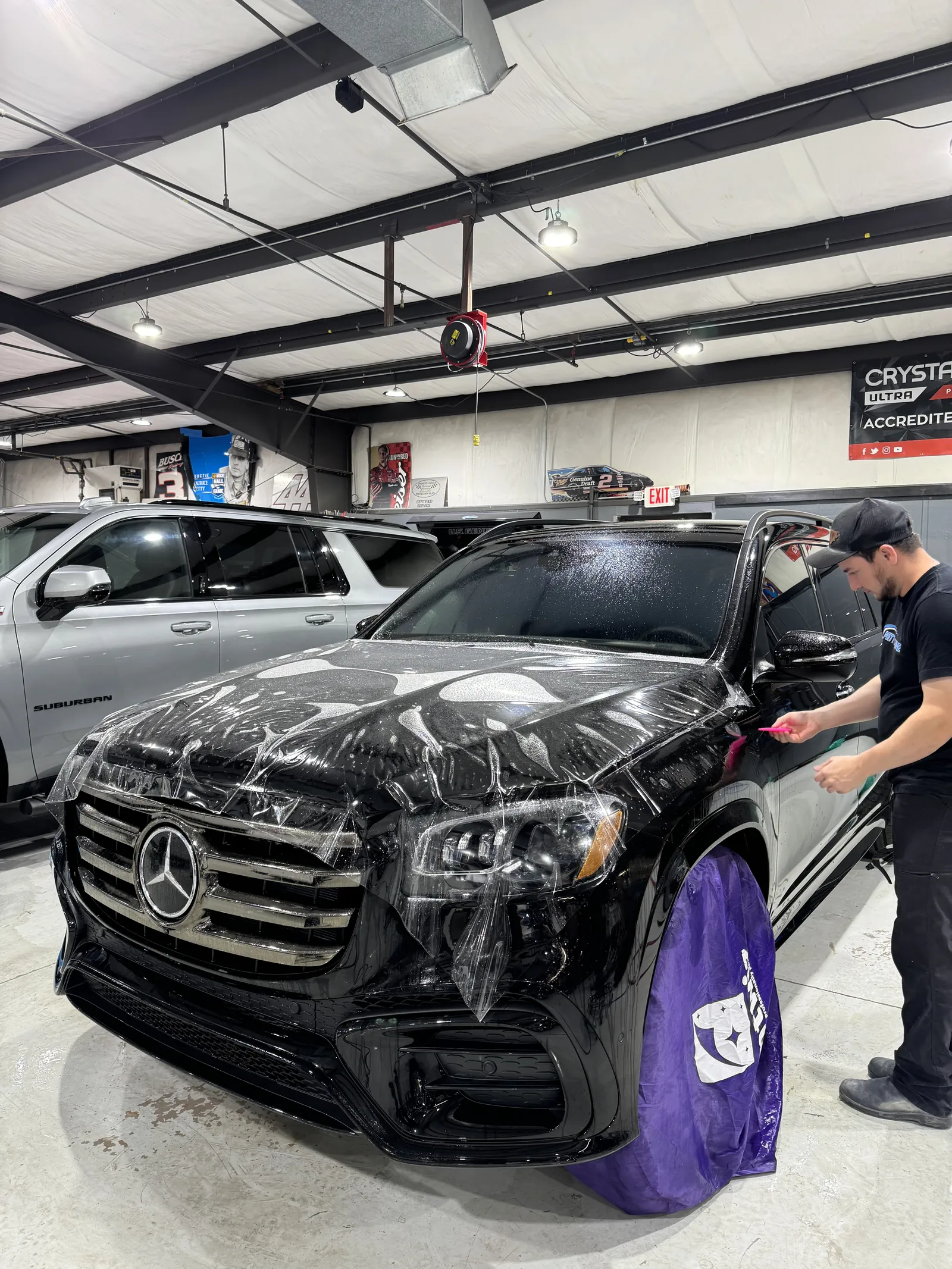Paint protection film being installed on the front of a black Mercedes-Benz GLS at Petty Shine