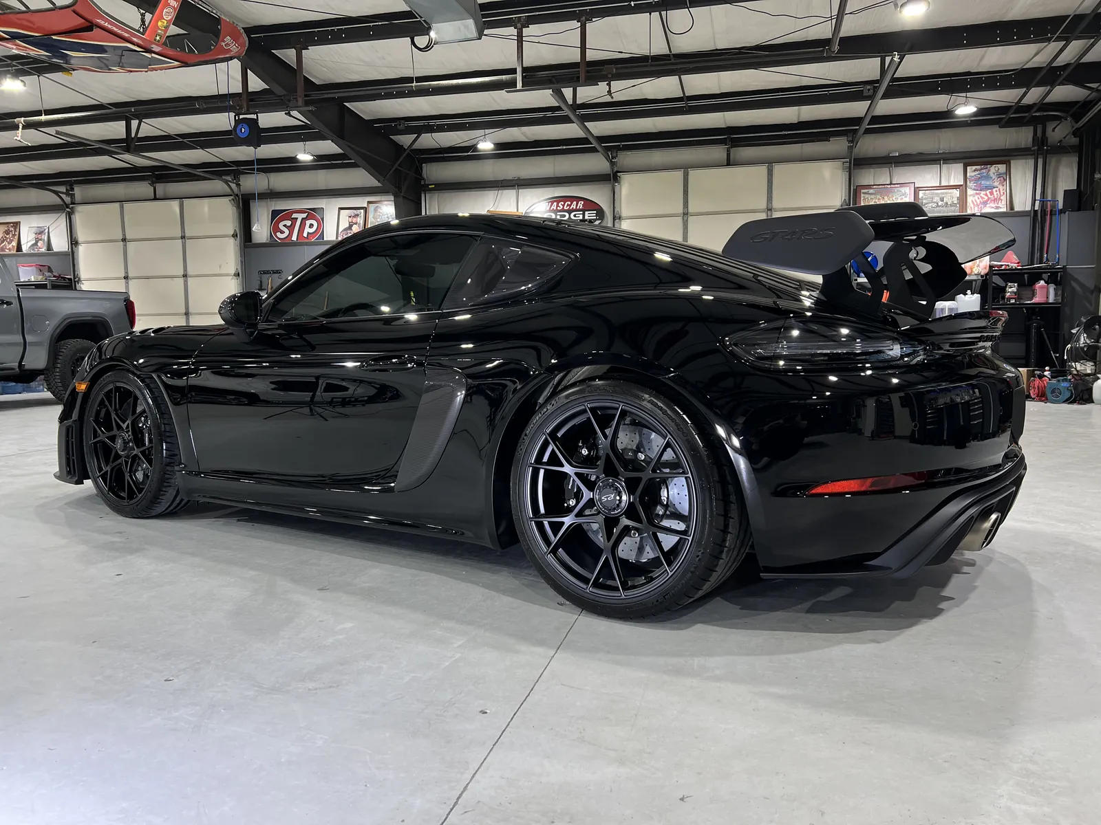 Black Porsche 718 Cayman GT4 RS inside the Petty Shine shop