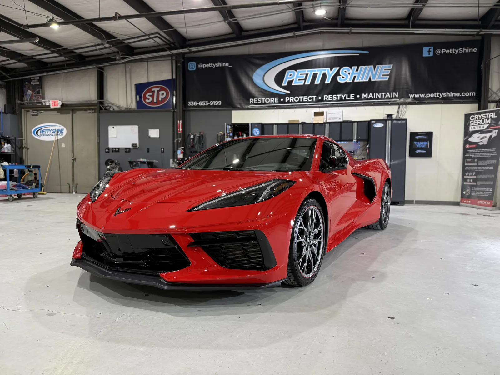 Red Chevrolet Corvette C8 under the Petty Shine banner in the Randleman shop