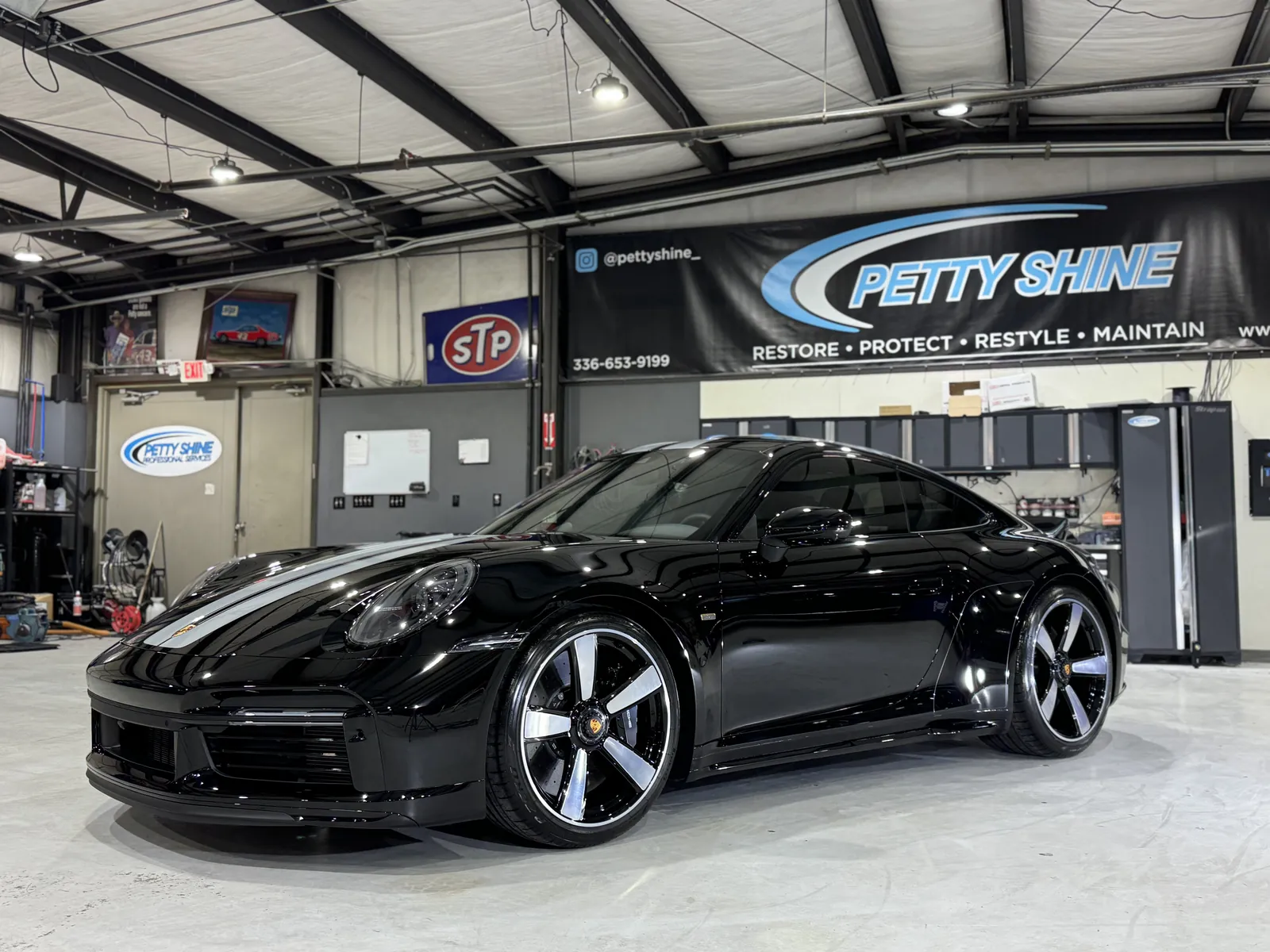 Black Porsche 911 under the Petty Shine banner in the Randleman shop